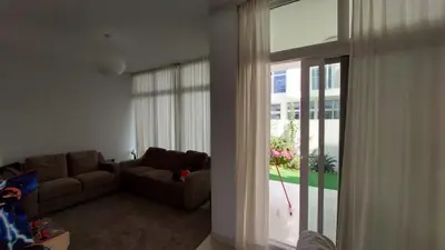 a living room with a couch and a large window at Damac hills 2 vardon cluster in Dubai