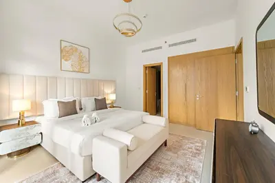 a white bedroom with a large white bed and a couch at FIRST CLASS 1BR Burj Views & Classy Comfort in Dubai