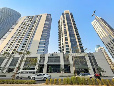 two tall buildings with cars parked in front of them at FIRST CLASS 1BR Burj Views & Classy Comfort in Dubai