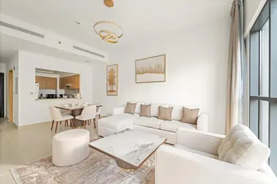 a living room with a white couch and a table at FIRST CLASS 1BR Burj Views & Classy Comfort in Dubai