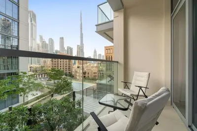 a balcony with two chairs and a view of the city at FIRST CLASS 1BR Burj Views & Classy Comfort in Dubai