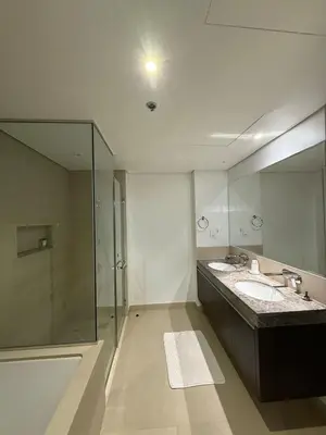 a bathroom with a shower and two sinks and a mirror at 3403!Dubai SkyLine View! Royal Montania Homes in Dubai