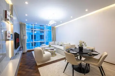 a living room with a couch and a table and chairs at Modern 1BR with High Floor Near Mall & Tram in Dubai