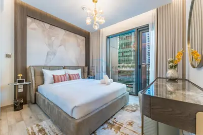 a bedroom with a large bed and a glass table at Furnished 1BR, Walk to Business Bay Metro, Near Downtown, Ahad Residences, Business Bay by Deluxe Holiday Homes in Dubai