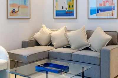 a living room with a couch with pillows and a table at Bright 1BR with Marina Views - Orra Marina - Allsopp & Allsopp in Dubai