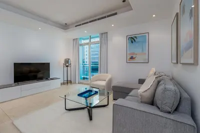 a living room with a couch and a tv at Bright 1BR with Marina Views - Orra Marina - Allsopp & Allsopp in Dubai