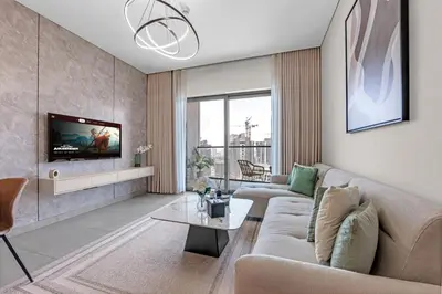 a living room with a couch and a tv at Relaxing 1BR w Maids room Minutes to Dubai Mall by Vibel in Dubai