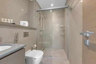a bathroom with a shower and a toilet and a sink at Relaxing 1BR w Maids room Minutes to Dubai Mall by Vibel in Dubai