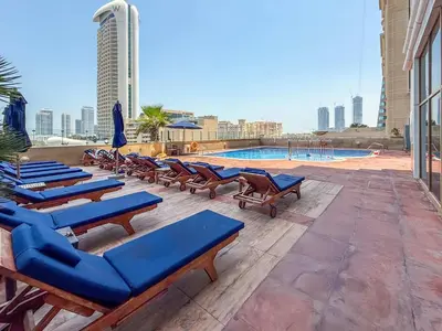 a row of lounge chairs and a swimming pool at Frank Porter - B324 - 5112 Elite Residence in Dubai