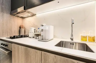 a kitchen with a sink and a coffee maker at Stylish Studio Near Miracle Garden - Luxury Amenities & Style in Dubai