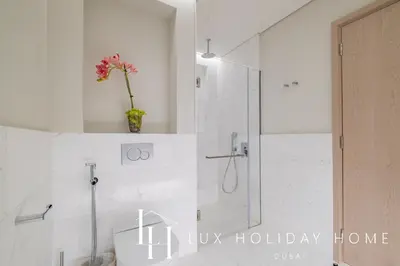 a white bathroom with a shower and a toilet at LUX Iconic Views at The Palm Tower Studio 3 in Dubai