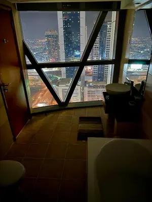 a room with a view of a city from a window at Damac Park Tower, Luxury 2BR with Stunning City Views in Dubai