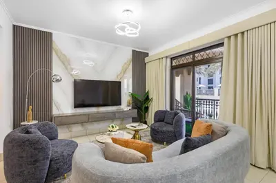 a living room with a couch and chairs and a television at Durrani Homes - Zaafaran Luxe Stay Iconic Burj View in Dubai