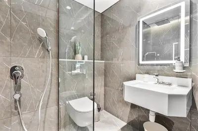 a bathroom with a shower and a toilet and a sink at Venetian - Relax in your private pool balcony in Dubai in Dubai