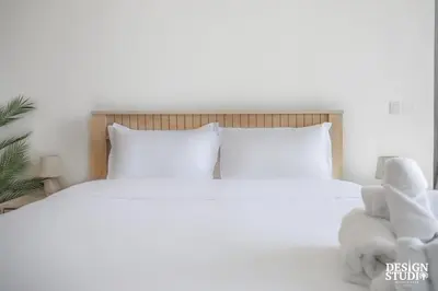 a bed with white pillows and a stuffed animal on it at LIGHT APARTMENT by Design Studio in Dubai
