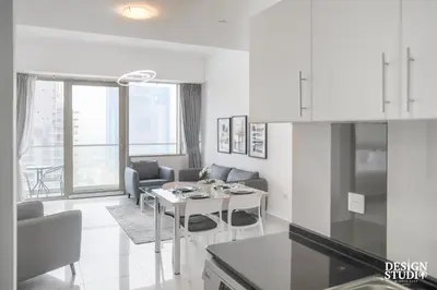 a kitchen and living room with a table and chairs at LIGHT APARTMENT by Design Studio in Dubai