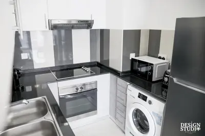 a small kitchen with a washer and a microwave at LIGHT APARTMENT by Design Studio in Dubai