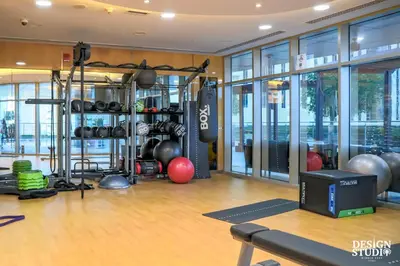 a gym with a bunch of equipment in a room at LIGHT APARTMENT by Design Studio in Dubai