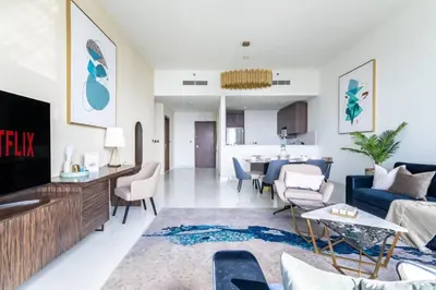 an open living room with a blue couch and a living room at GuestReady - Sea view retreat overlooking The Palm in Dubai