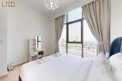 a bedroom with a white bed and a large window at Chic 1BR with Canal View in Dubai