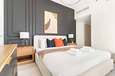 a bedroom with a large white bed with orange pillows at Silkhaus Luxurious 3BR with Maid Room in Dubai Hills in Dubai