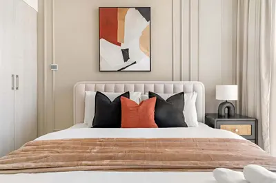 a bedroom with a bed with orange and black pillows at Silkhaus Luxurious 3BR with Maid Room in Dubai Hills in Dubai