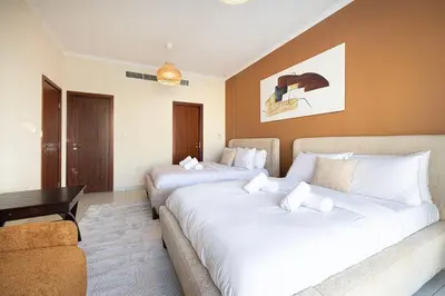 a hotel room with two beds and a couch at Panoramic Burj & Fountain Views 2BR in Dubai