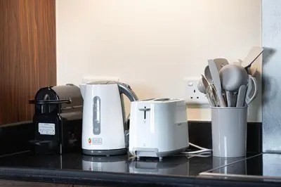 a kitchen counter with two coffeemakers and utensils at Panoramic Burj & Fountain Views 2BR in Dubai