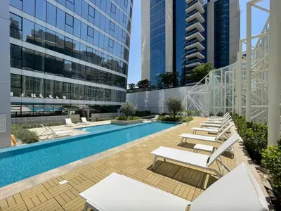 a swimming pool with lounge chairs and buildings at Remarkable one BR in Business Bay with Canal View in Dubai