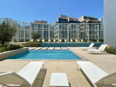 a swimming pool with lounge chairs and a building at Remarkable one BR in Business Bay with Canal View in Dubai