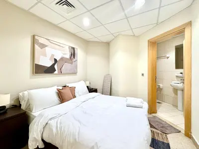 a bedroom with a large bed and a bathroom at Palm Paradise Walk to Beach in Dubai
