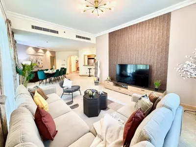 a living room with a couch and a television at Palm Paradise Walk to Beach in Dubai