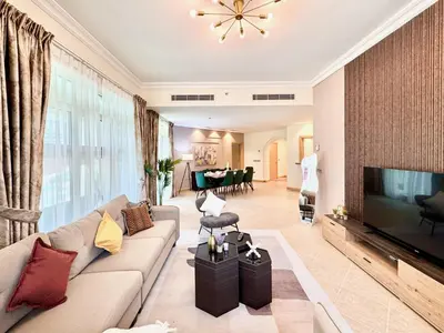 a living room with a couch and a flat screen tv at Palm Paradise Walk to Beach in Dubai