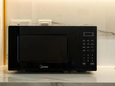 a microwave oven sitting on top of a counter at Cozy New Studio Heart of Al Furjan in Dubai