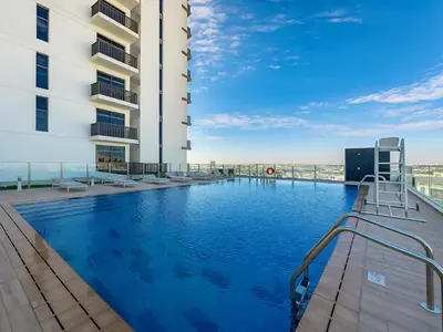 a swimming pool on the roof of a building at Cozy New Studio Heart of Al Furjan in Dubai