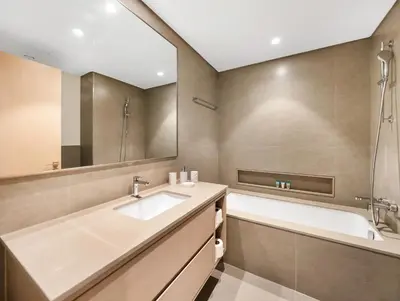 a bathroom with a sink and a tub and a mirror at Spacious, Modern Chic 2 BDR Apartment in Prime Downtown Location in Dubai