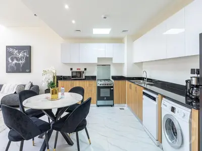 a kitchen with a table and chairs in a room at Cozy house suitable for family in Dubai