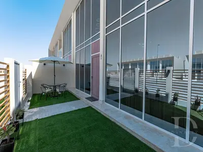 a balcony with a table and an umbrella on a building at Cozy house suitable for family in Dubai