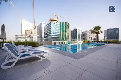 a couple of lounge chairs sitting next to a swimming pool at Luxury Escapes Modern 1 Bed Apt City View Sol Bay Business Bay in Dubai