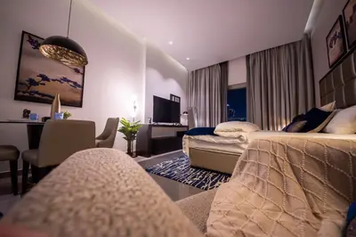 a hotel room with two beds and a desk at Mejestic Studio in Dubai