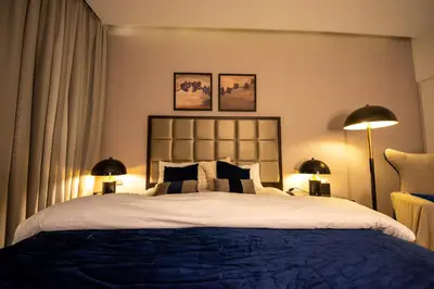 a bedroom with a large bed with two lamps at Mejestic Studio in Dubai