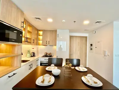 a kitchen with a table and two chairs in it at Homes2Retreat - Modern Comforts 1 BR in Liva Lush Living in Dubai