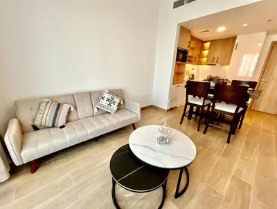 a living room with a couch and a table at Homes2Retreat - Modern Comforts 1 BR in Liva Lush Living in Dubai
