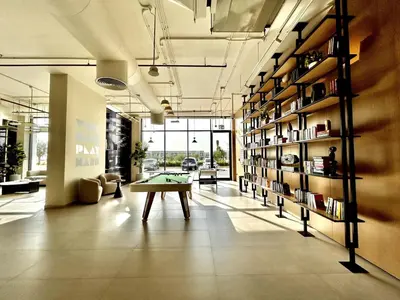 a room with a ping pong table and a book shelf at Homes2Retreat - Modern Comforts 1 BR in Liva Lush Living in Dubai