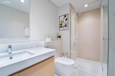 a bathroom with a toilet sink and a shower at Gardenia Suites Creek Harbour, 2 Bedroom Stylish Apartment with Creek Views in Dubai
