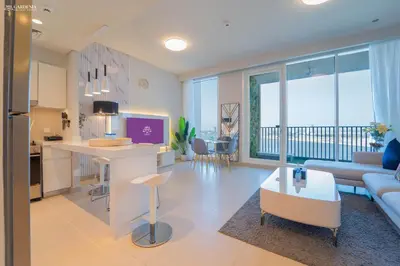 a kitchen and living room with a couch and a table at Gardenia Suites Creek Harbour, 2 Bedroom Stylish Apartment with Creek Views in Dubai