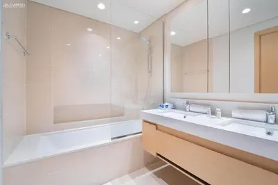 a bathroom with a tub and a sink and a shower at Gardenia Suites Creek Harbour, 2 Bedroom Stylish Apartment with Creek Views in Dubai