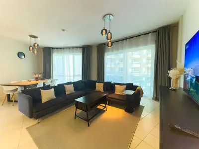 a living room with a couch and a table at Spacious 2BR in Lago Vista Tower in Dubai