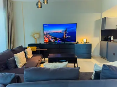 a living room with a couch and a flat screen tv at Spacious 2BR in Lago Vista Tower in Dubai