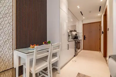 a kitchen and dining room with a white table and chairs at DAYF-LAV Brand New Apartment with Balcony in JVC in Dubai